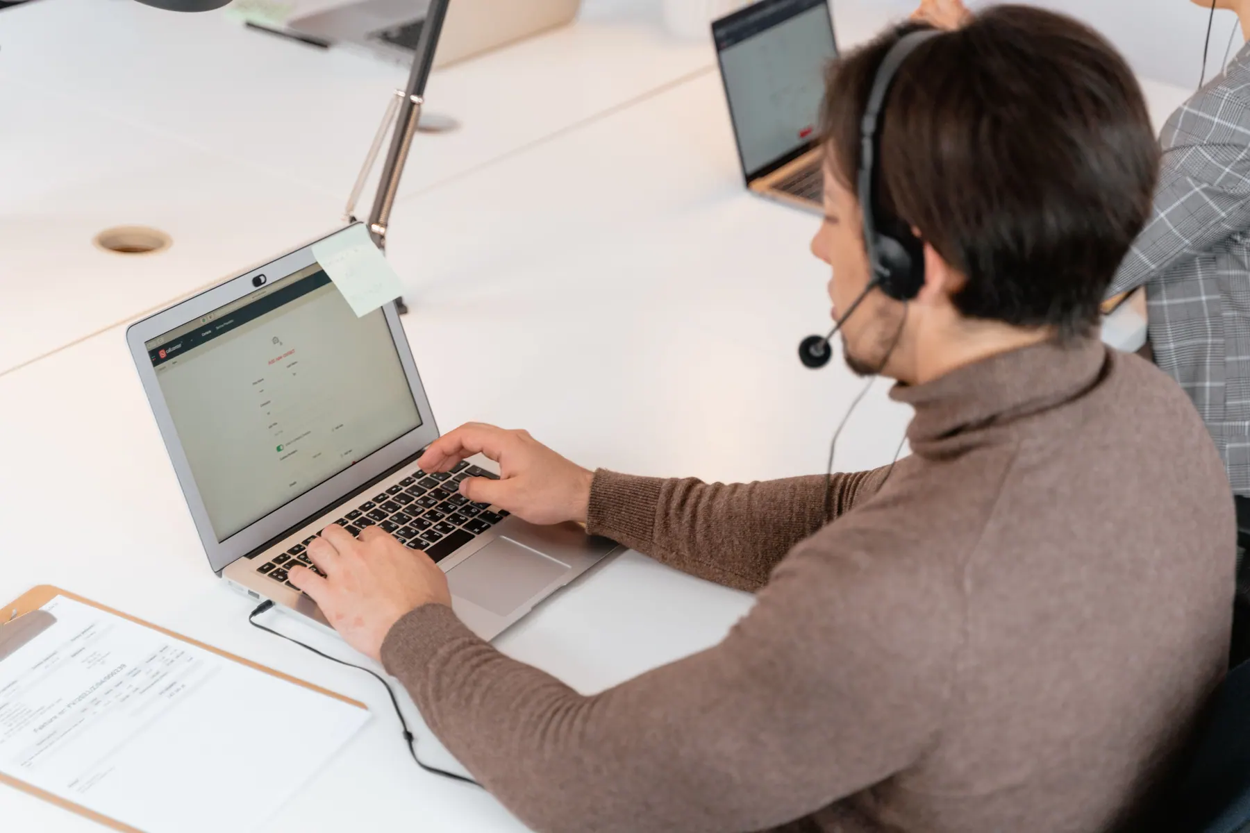 Two people discussing a business project and reviewing documents